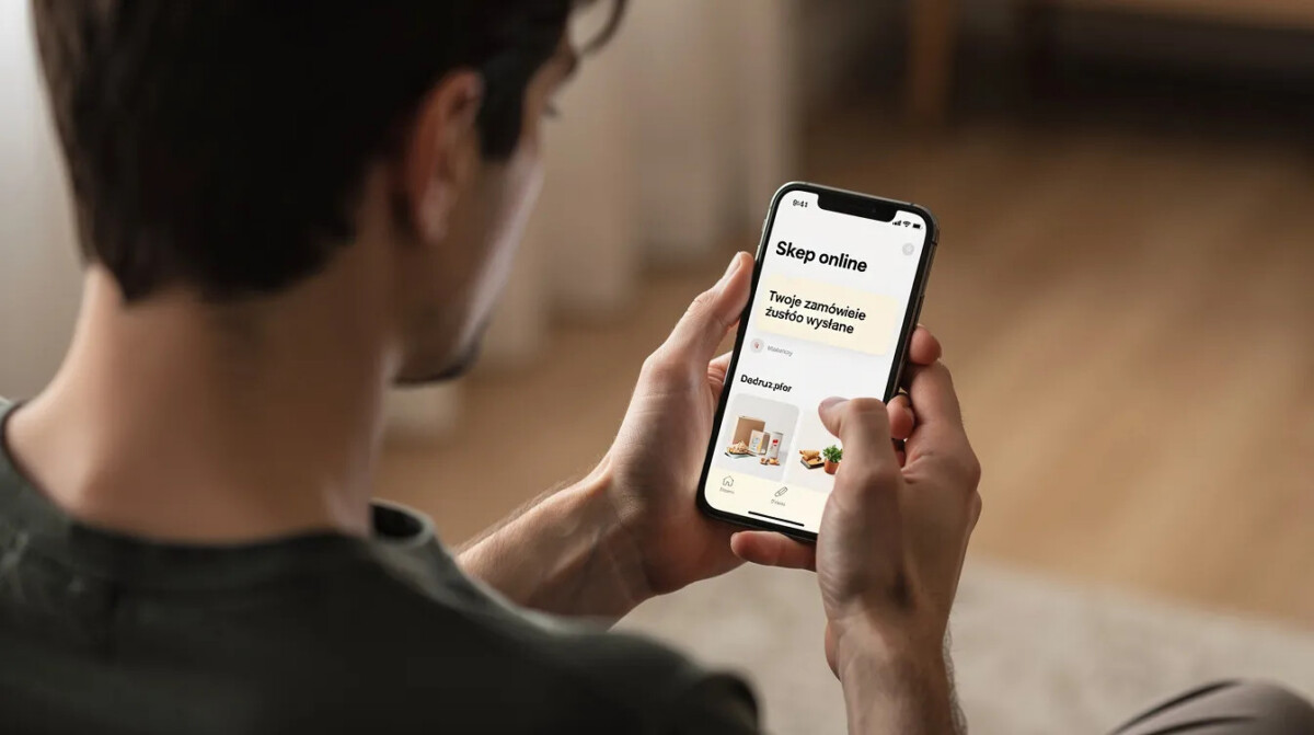 Na obrazku widoczna jest osoba, która z uwagą patrzy na ekran swojego telefonu, gdzie wyświetla się powiadomienie dotyczące zamówienia złożonego w sklepie internetowym. To może być istotne dla analizy doświadczenia klienta, zwłaszcza w kontekście anulowania zamówienia i jakości obsługi klienta.